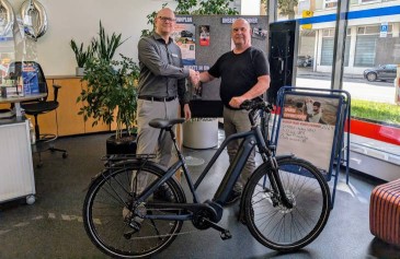 Gewinner eines E-Bikes vor Sparda-Bank Filiale